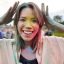 Face of smiling woman with coloured powder at Holi Festival