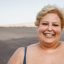 Portrait of curvy woman smiling on camera wearing bikini at the beach - Focus on face